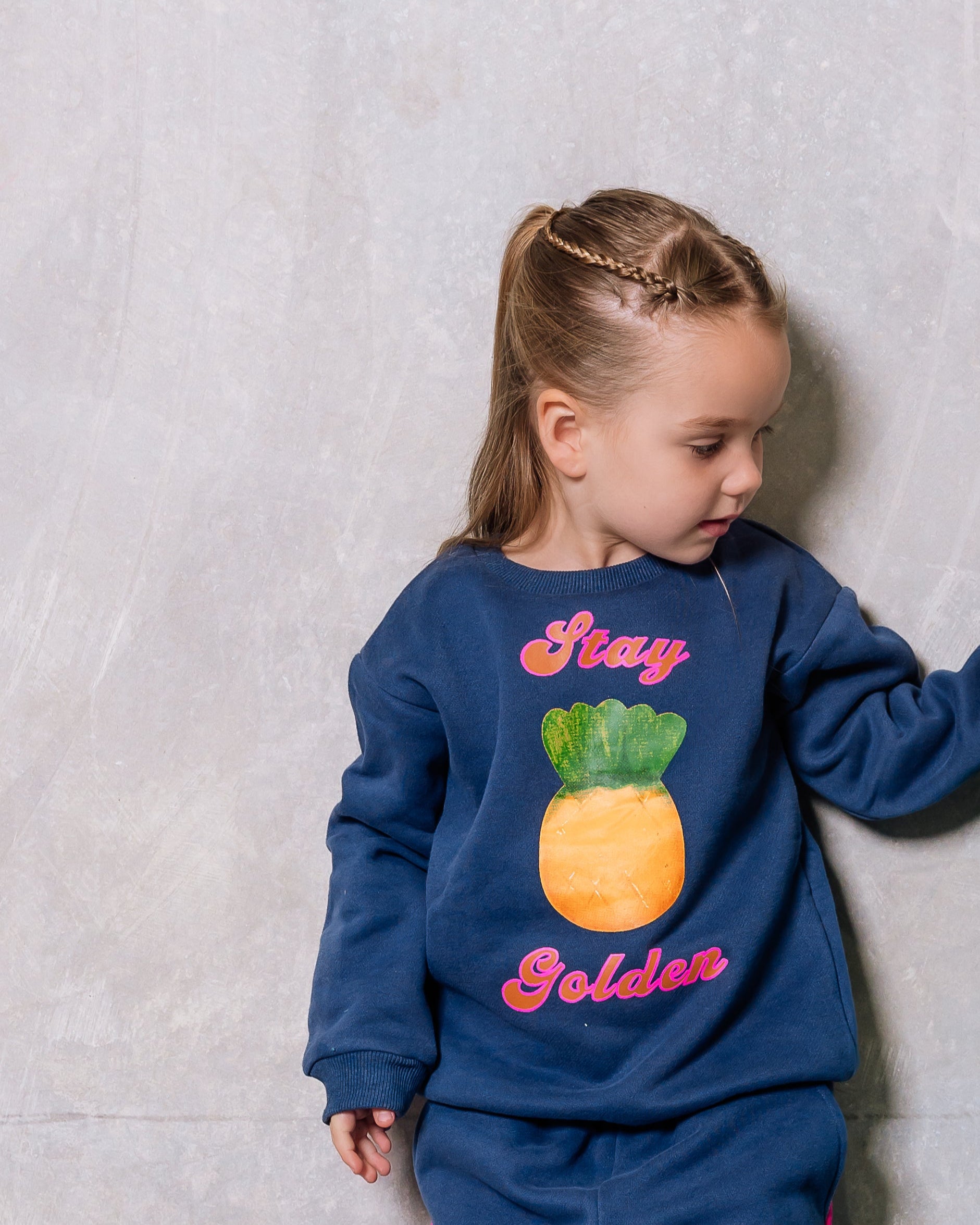 Two children wearing blue and green pajamas with text and graphics against a plain background